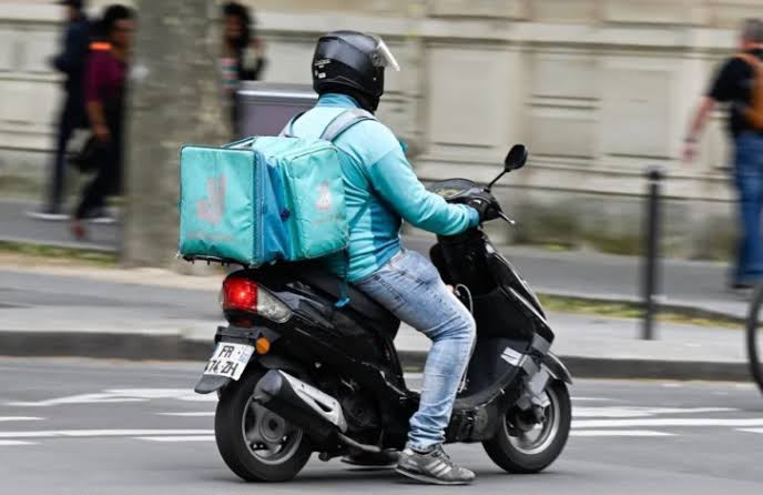 A delivery person on a scooter