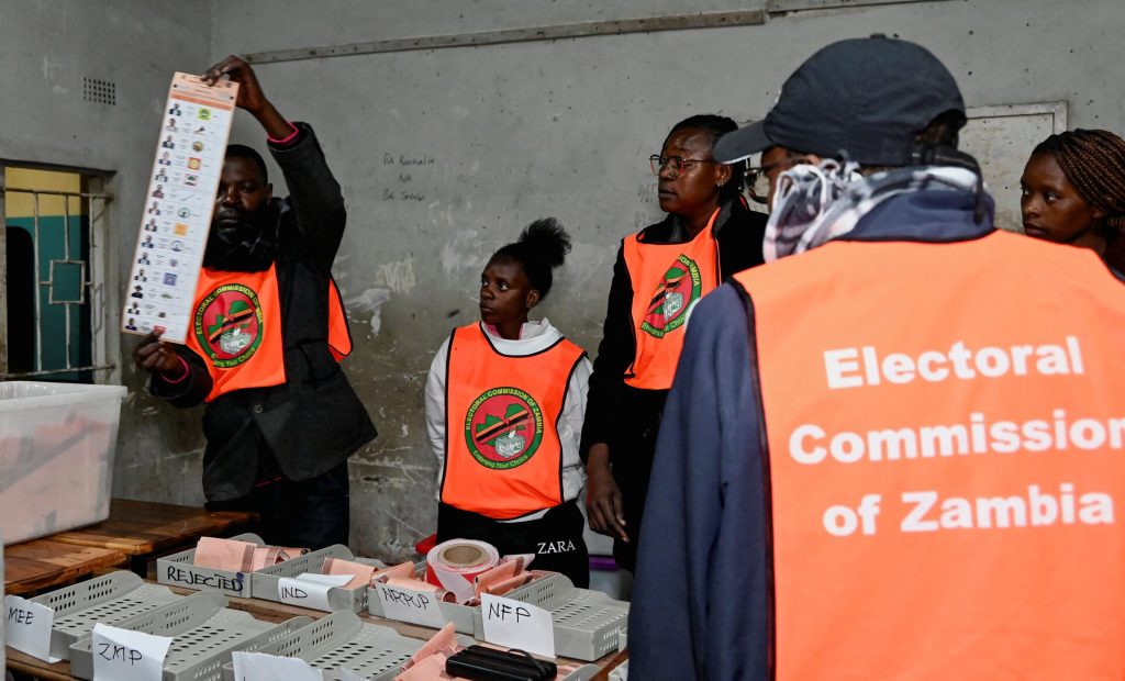 An election official displays a ballot paper as observers look on during the counting of votes after the polls closed at a polling station in Lusaka, Zambia, during Zambia's general elections, including the presidential election. REUTERS/Moses Mwape