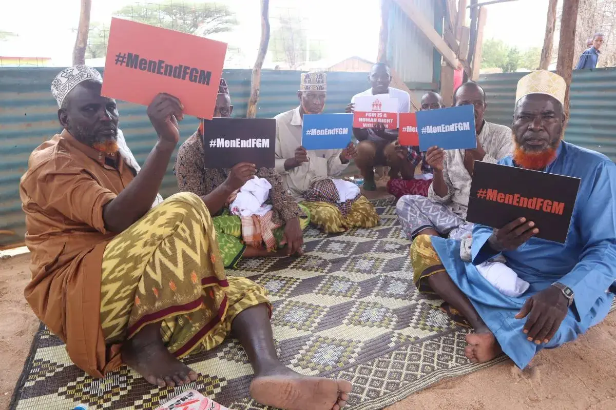 Men hold anti fgm signs