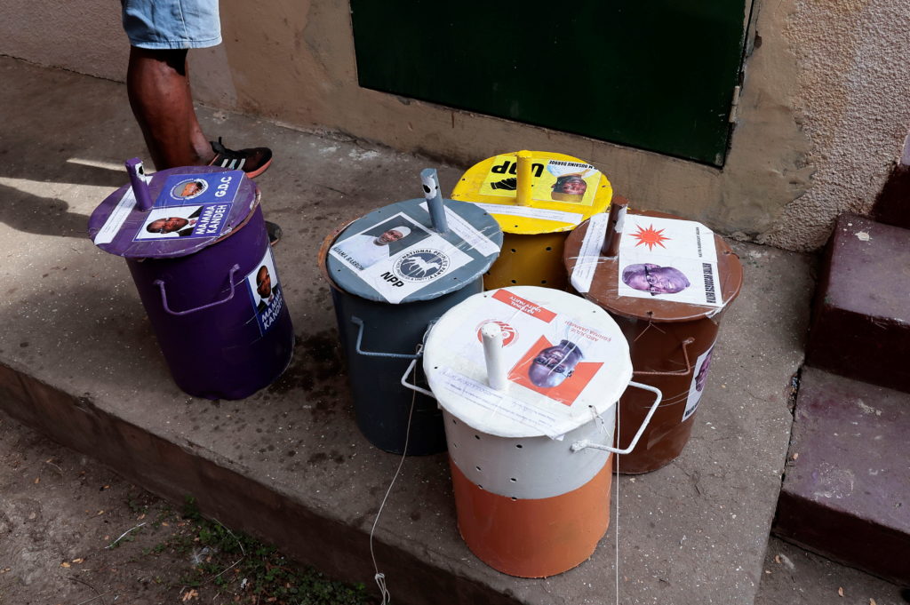A Gambian election commission worker stands beside ballot boxes as he arrives to prepare a polling station ahead of the presidential election in Banjul, Gambia, December 3, 2021. REUTERS/Zohra Bensemra