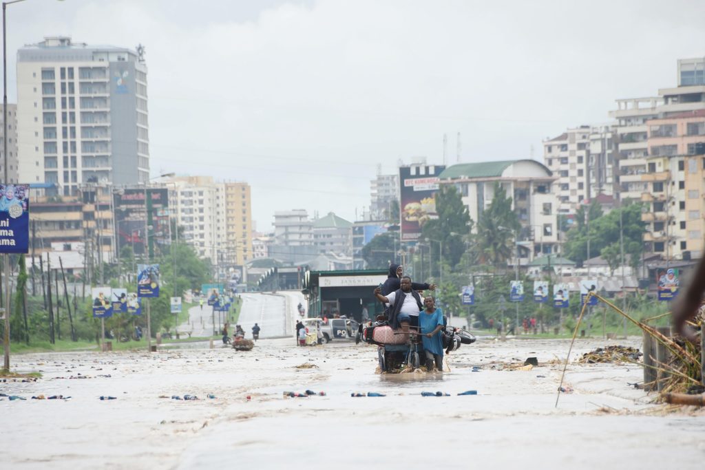 People passing over a flooded section of Morogoro road at Jagwani area. PHOTO | ERICKY BONIPHACE