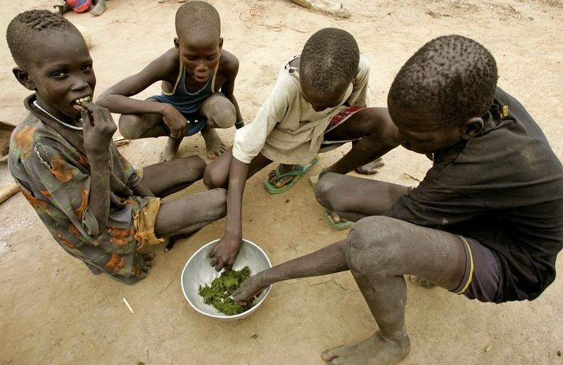 Four children share food from a communal bowl. Sudan’s hunger crisis has left millions facing severe food shortages as conflict disrupts livelihoods and access to assistance.