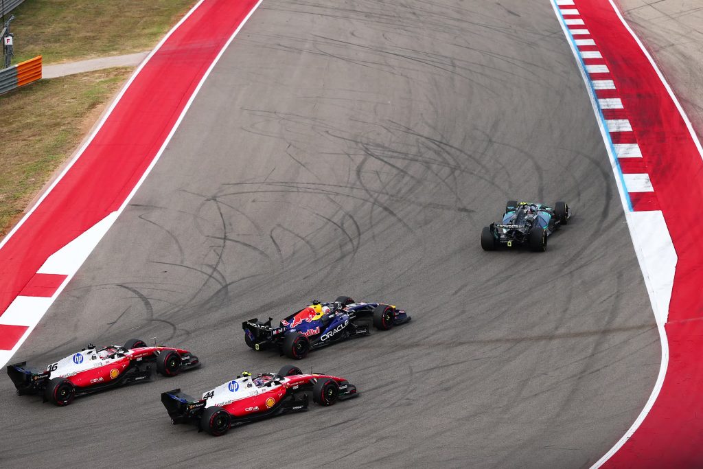 Cars from Mercedes, Red Bull and Ferrari race through a corner at the Circuit of The Americas during the United States Grand Prix.