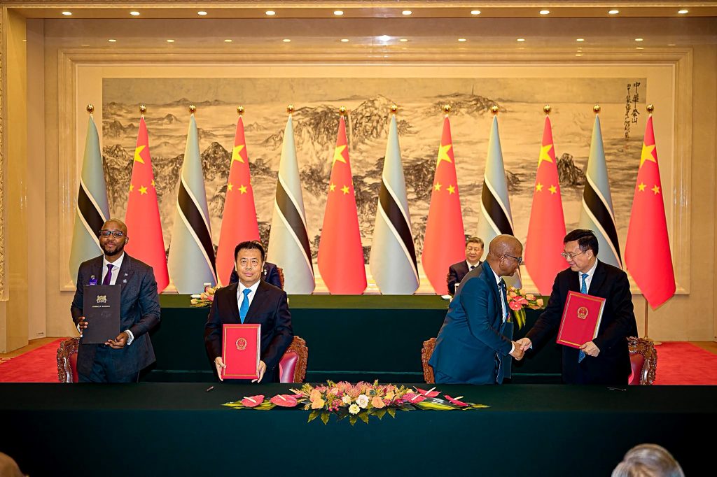 Officials from Botswana and China exchange signed agreements, with President Xi Jinping seated in the background, during the signing ceremony in Beijing.