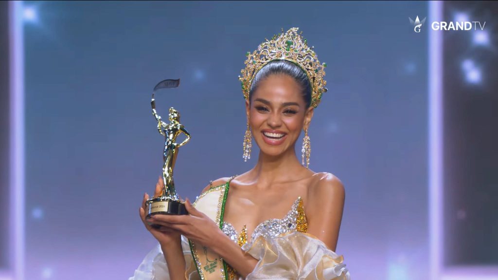 Dimack holds up her trophy moments after her crowning. She is the first woman from an African country to win the Miss Grand International title.